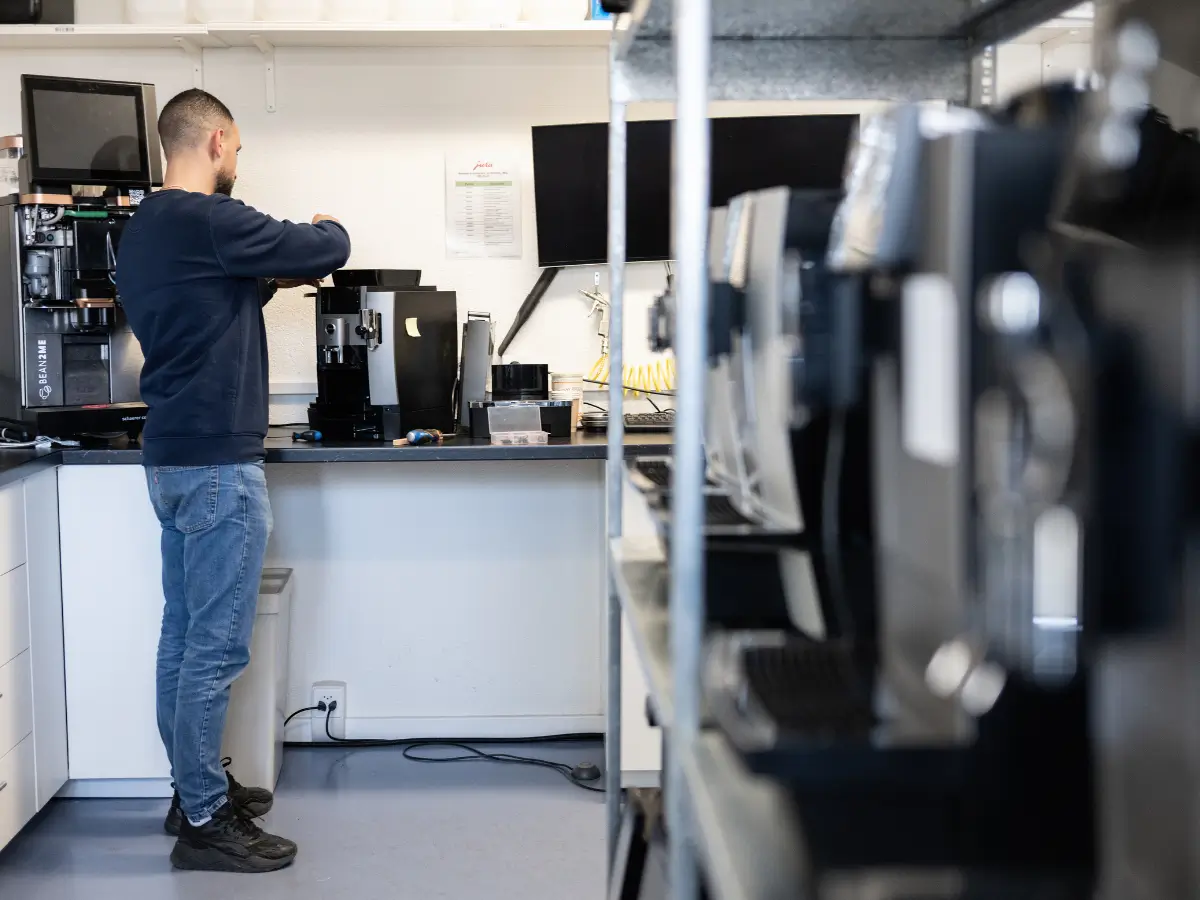 Technicien Bean2me réparant une machine JURA à l'atelier
