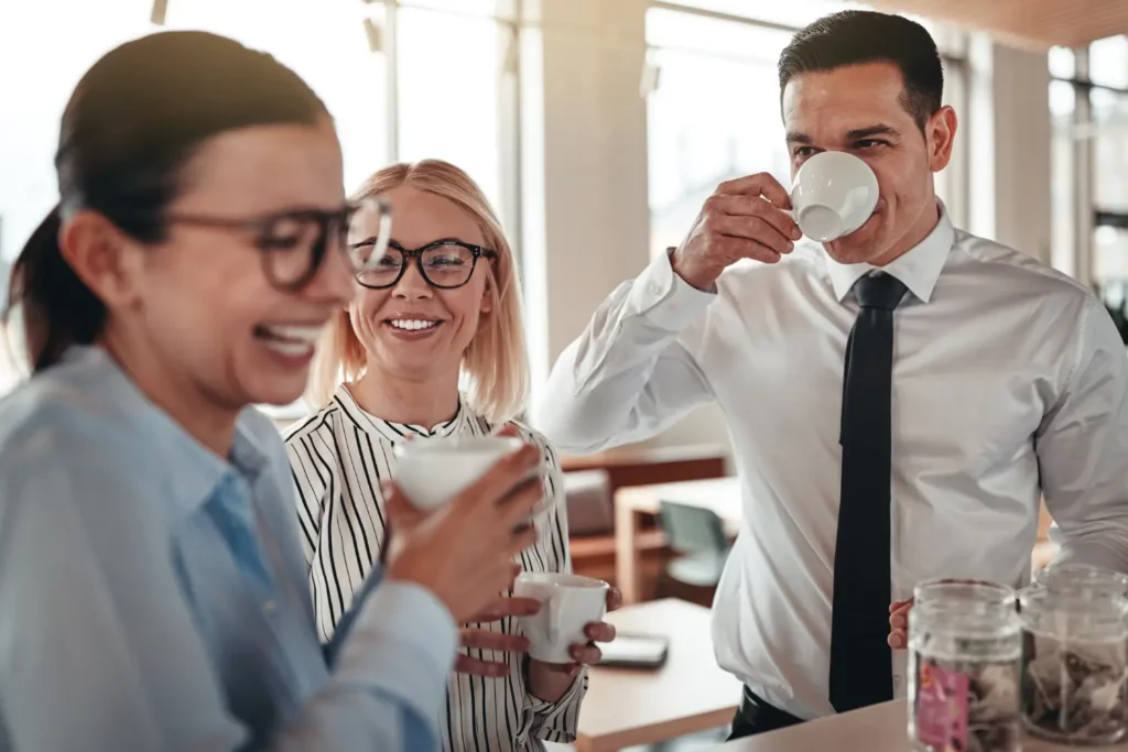 Trois employé·es rient ensemble en pause café